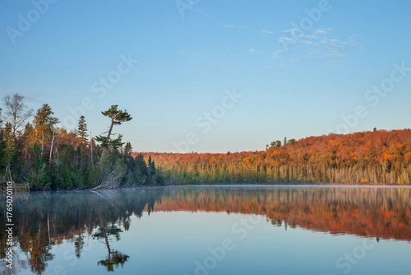 Obraz Beautiful calm northern Minnesota lake below hills in fall color on a clear autumn morning