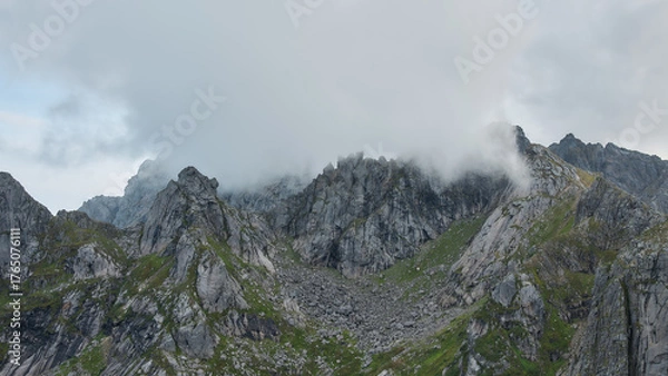 Fototapeta Cloudy peaks of mountain ridge, Norway