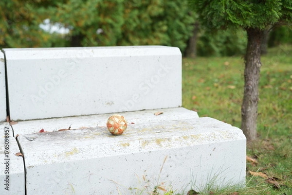 Fototapeta A white bench with a ball on it