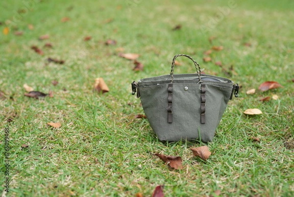 Fototapeta A small purse is sitting on the grass