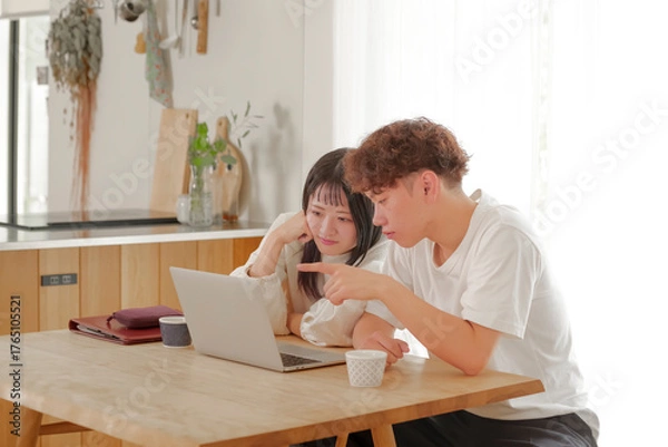 Obraz パソコンを見ながらお金の管理を行う夫婦