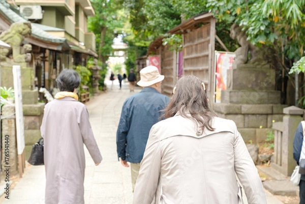 Fototapeta 緑に囲まれた参道を歩く人々の静かな時間