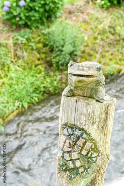 Fototapeta 開成町の小川に佇む木彫りのカエル
