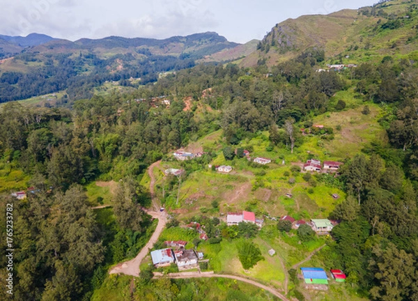Fototapeta A stunning aerial view of Maubisse village in the highlands of Ainaro, Timor-Leste. Houses are scattered across the ridges and valleys, surrounded by a vast, green mountain landscape