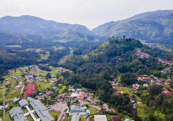 Fototapeta An aerial view of a public building complex, in the mountain town of Maubisse, Ainaro, Timor-Leste. The facility is set amidst a lush green highland landscape.