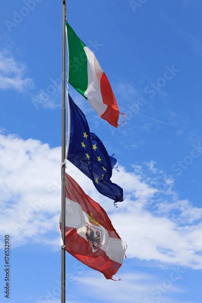 Obraz The Italian, Austrian and Eu flag blows in the wind at Lake Garda, Italy.