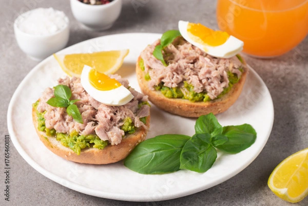 Fototapeta Two delicious tuna open sandwiches with avocado and boiled eggs. Tuna toast.