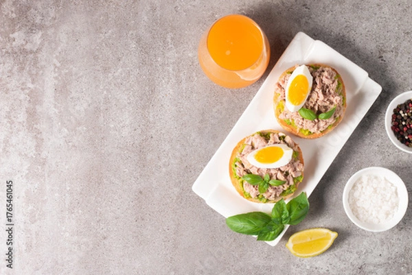 Fototapeta Two delicious tuna open sandwiches with avocado and boiled eggs. Tuna toast.