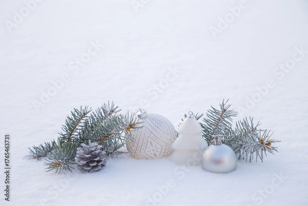 Fototapeta Christmas decorations and fir branches in fluffy snow. Copy space.