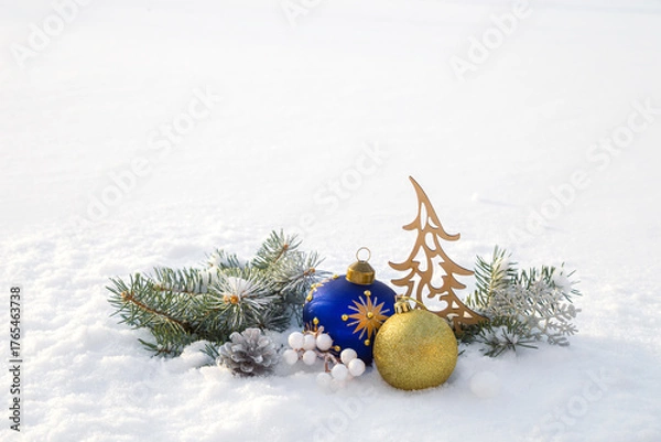 Fototapeta Christmas decorations and fir branches in fluffy snow. Copy space