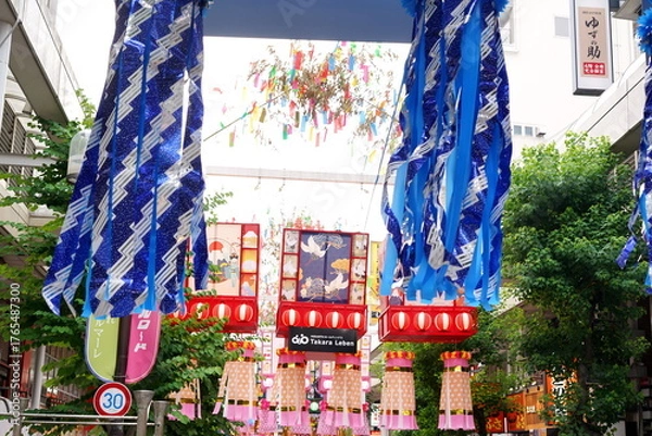 Obraz 青と白を基調とした巨大な七夕飾りが商店街の上空を覆いつくし賑やかな夏の祭りの雰囲気を伝える写真です