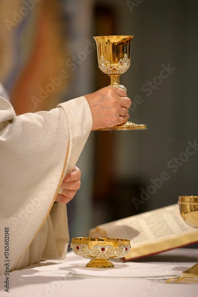 Fototapeta Chalice in the hands of the priest on the altar during the celebration of the mass