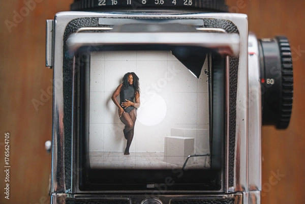 Fototapeta A confident young woman in the photo studio feels positive and comfortable in her body. Body Positive and vitality concept in a studio.