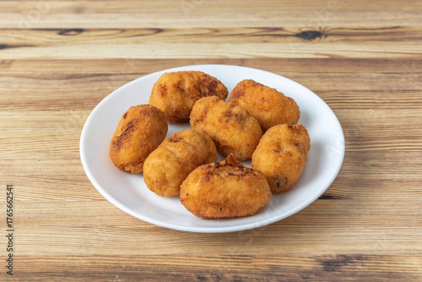 Fototapeta Traditional homemade croquettes with thick chicken and ham béchamel, perfectly browned and sprinkled with freshly chopped parsley