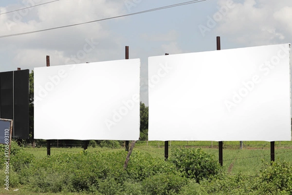 Fototapeta india Billboard on rural area of India, outdoor advertising, mockup billing board in front of green tree and Blank white background for branding design large hoarding. Outdoor advertising construction