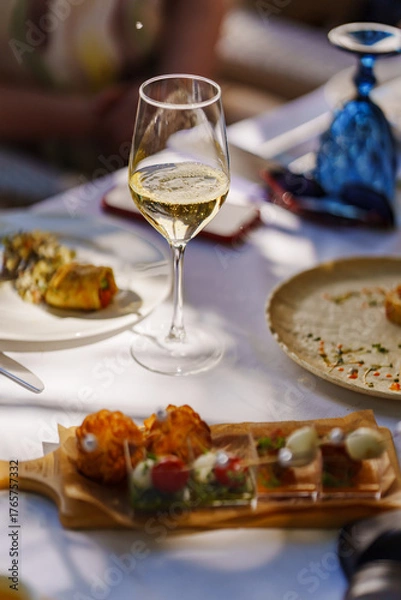 Fototapeta Enjoying gourmet dishes and wine in a sunny setting