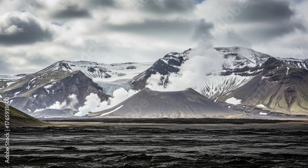 Fototapeta Volcano emitting steam and smoke with snowcapped mountains in the background