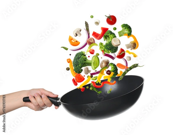 Obraz Hand holding a wok with colorful vegetables flying out isolated on transparent background