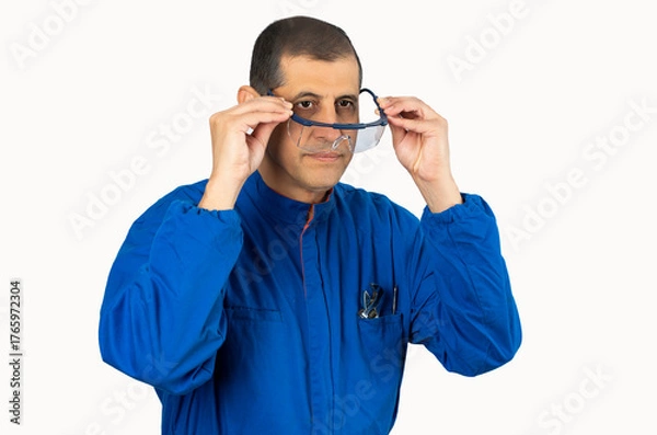 Fototapeta Mechanic worker putting protective glasses before work with white background.