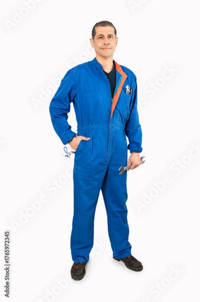 Fototapeta Full length portrait of a mature male worker in an overall uniform posing and smiling isolated on white background