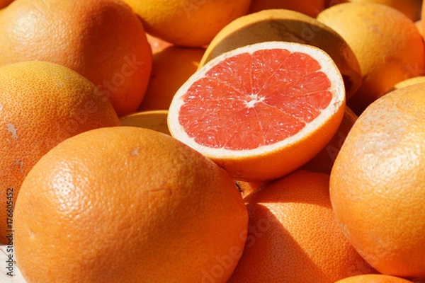 Fototapeta Ripe half of the grapefruit is on the counter at the fruit market in Spain