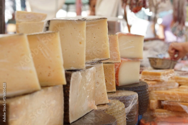 Fototapeta Many cut cheeses on the counter in the market