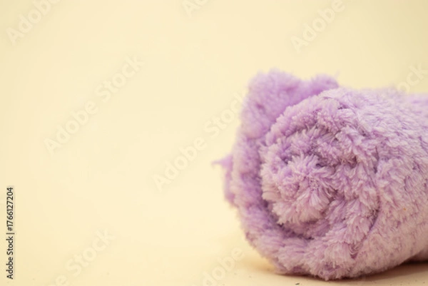 Obraz Folded purple towel on beige background