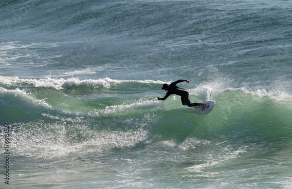 Fototapeta Aerial view of unrecognizable male wave surfer ride on a wave