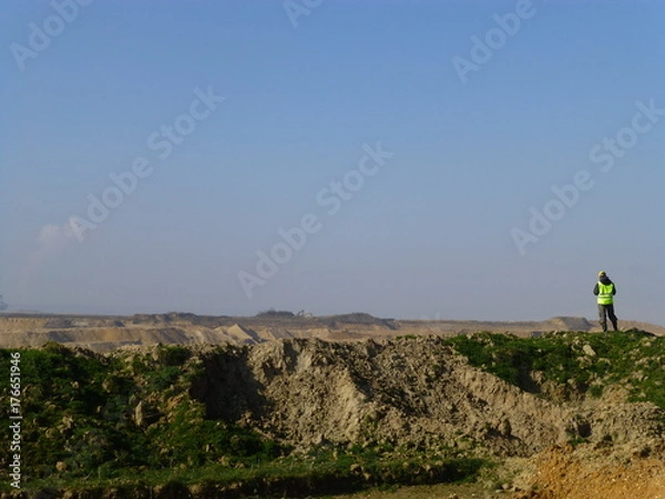 Fototapeta Construction worker in front of a huge coal mining area