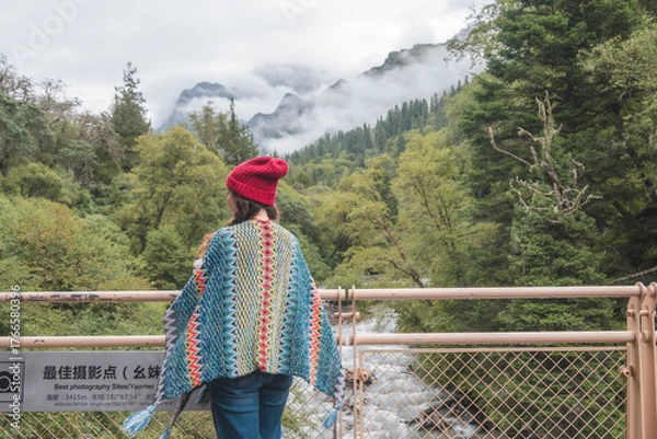 Fototapeta happy woman tourist trekking at mountain in Changping valley near Siguniang mountain in Sichuan province, China, color effect, low key and soft focus.