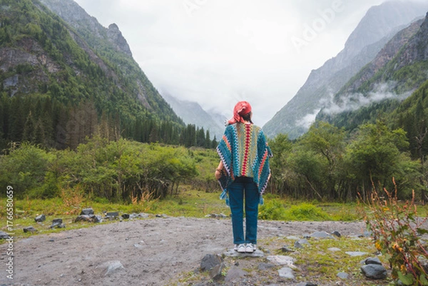 Fototapeta happy woman tourist trekking at mountain in Changping valley near Siguniang mountain in Sichuan province, China, color effect, low key and soft focus.