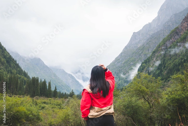 Fototapeta happy woman tourist trekking at mountain in Changping valley near Siguniang mountain in Sichuan province, China, color effect, low key and soft focus.