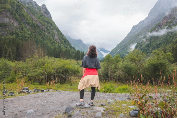 Obraz happy woman tourist trekking at mountain in Changping valley near Siguniang mountain in Sichuan province, China, color effect, low key and soft focus.