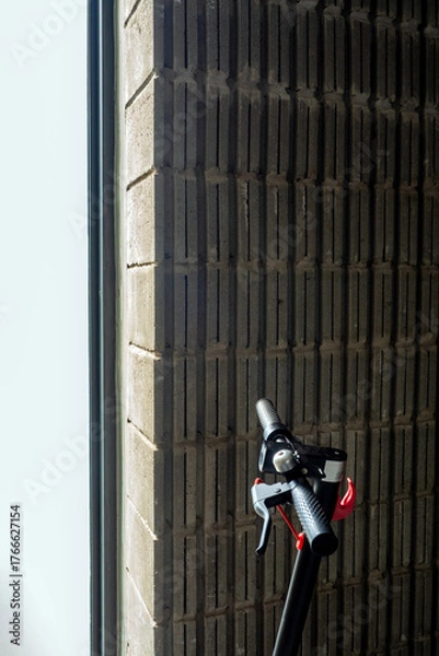 Fototapeta Light from outside the building shines into the part of the electric scooter