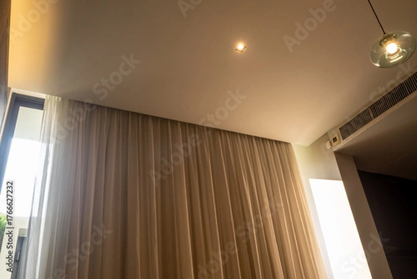 Fototapeta Bright light from outside poured into the room through the side of the curtains