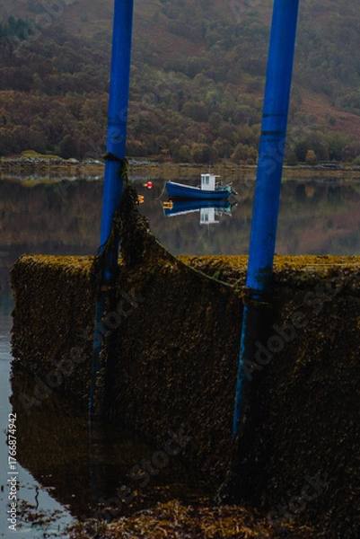 Obraz A boat is seen with it's refection in the tranquil waters of Loch Sunart, Scottish Highlands, on a peaceful day

