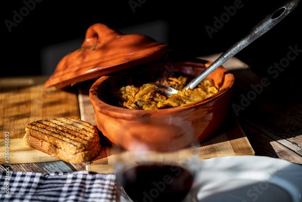 Fototapeta A bowl of cooked cabbage served in a rustic brown dish, showcasing its soft texture and warm, comforting appearance. The natural colors and simple presentation make this image suitable for traditional