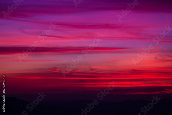 Fototapeta A winter sky glows with deep blues and soft pinks, merging into violet at sunset, evoking the moods of All Saints Day, Halloween, and the hope of Easter.