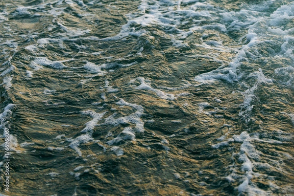 Fototapeta Dynamic ocean waves with foam and sunlight reflections