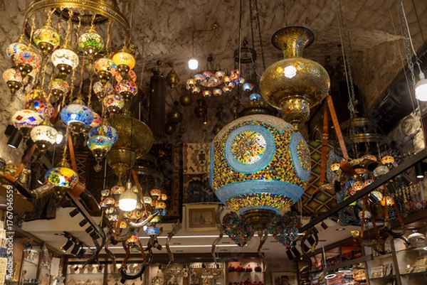 Obraz Jerusalem, Israel, 23 October 2025, Numerous vibrant and intricately designed turkish mosaic lamps and lanterns hang from the stone ceiling of a souvenir shop