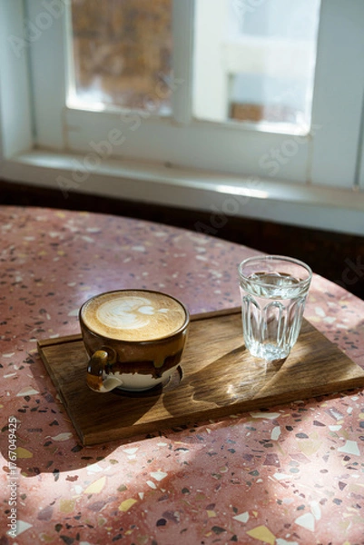 Fototapeta Hot coffee latte with latte art milk foam in cup mug on marble floor desk As breakfast In a coffee shop at the cafe, during business work concept