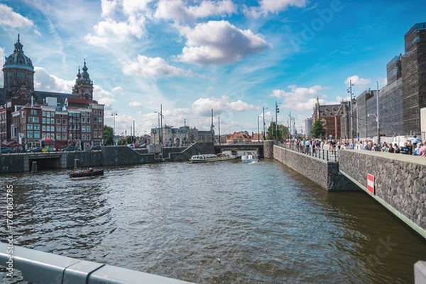 Fototapeta Amsterdam, Netherlands, August 20, 2025, view of a canal in a cosmopolitan city