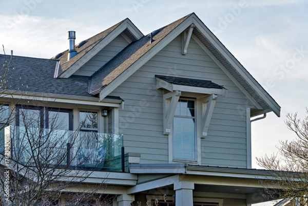 Obraz Top of residential house with small patio on overcast sky background