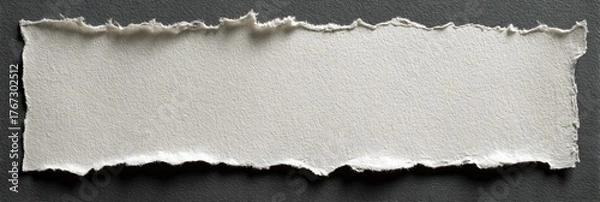 Obraz A ripped piece of off-white paper against a dark gray background