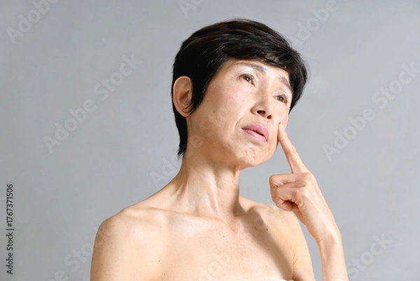 Obraz 肌を気にする困り顔の中高年のアジア人女性