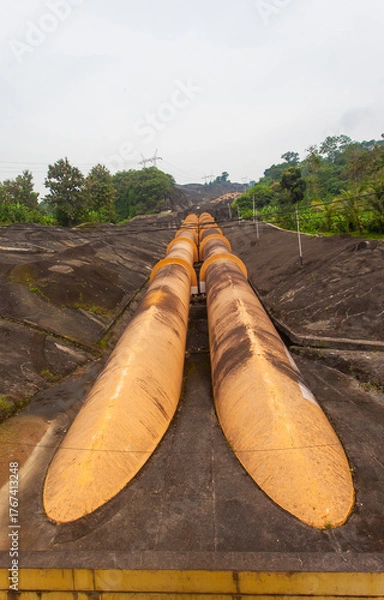 Fototapeta Giant penstock pipes at the Saguling Hydroelectric Power Plant in West Java, Indonesia. These massive pipes channel water to turbines, generating renewable energy.