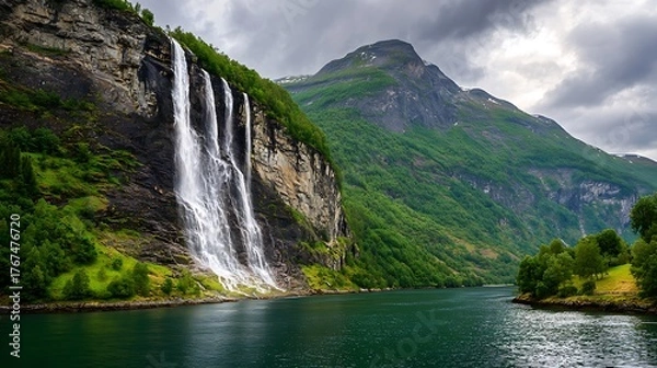 Obraz Powerful waterfall plunges into a dark fjord under a cloudy sky