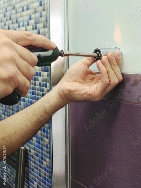 Fototapeta Man drilling a hole in the tile of bathroom