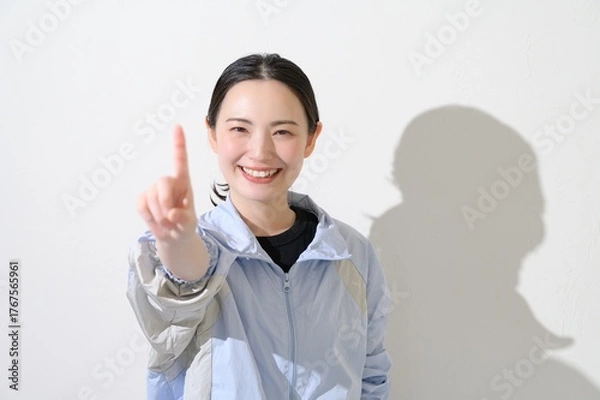 Obraz スポーツウェアを着て指をさす日本人女性
