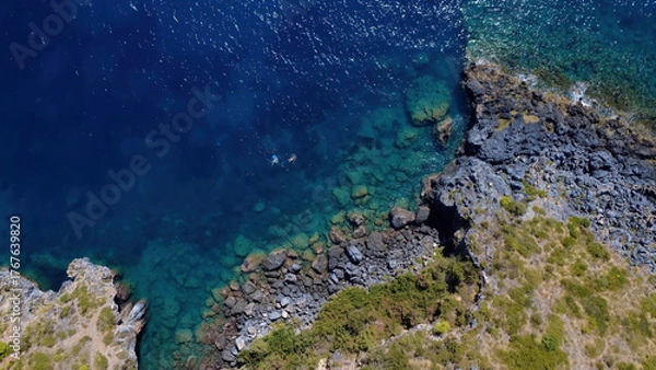 Fototapeta Serene Coastal View With Rocky Shoreline and Clear Blue Waters During Sunny Day